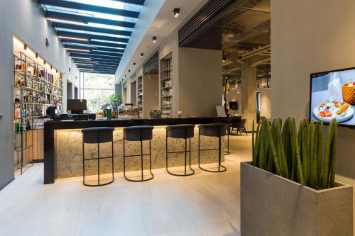 a lobby with a bar with stools in a store at Hotel Mona Plaza in Belgrade