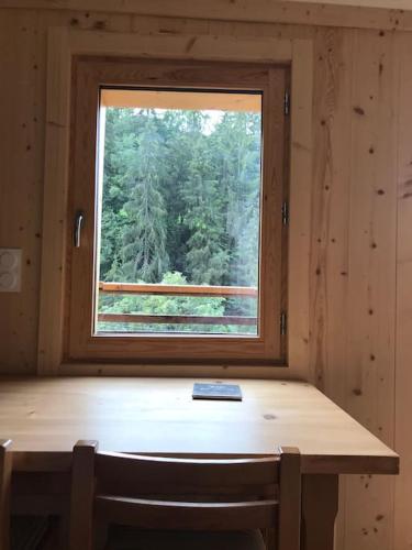 - une table en bois dans une chambre avec fenêtre dans l'établissement Studio à la montagne Flumet, à Flumet