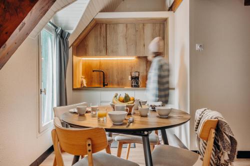 a kitchen with a table with a bowl of fruit on it at ISKÖ CHALETS-HÖTEL, Col d'Aubisque in Gourette