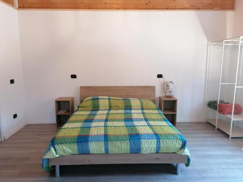 a bedroom with a bed with a colorful blanket on it at Agriturismo bio Apipoli in Lucino