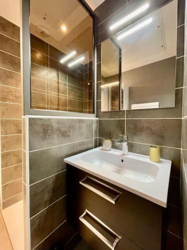 une salle de bain avec un lavabo et un miroir dans l'établissement Appartement 3 ch vue mer O Fil de L'eau Bandol, à Bandol