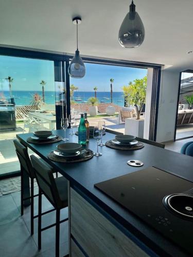 - une cuisine avec une table et une vue sur l'océan dans l'établissement Appartement 3 ch vue mer O Fil de L'eau Bandol, à Bandol