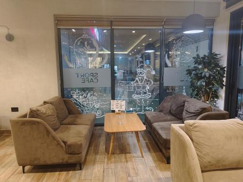 a living room with couches and a table in front of a store at H.T Hotel in Belgrade