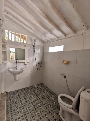 a bathroom with a toilet and a sink at Exotic house in Gili Meno