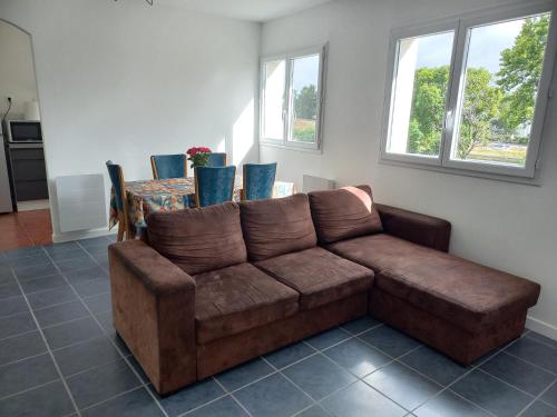 - un canapé brun dans le salon doté de fenêtres dans l'établissement Habitación Saint Herblain Cerca a Nantes, à Saint-Herblain