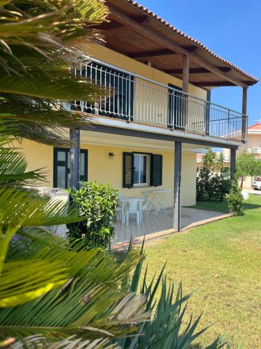 a house with a balcony and a table at Luna Apartments in Badolato