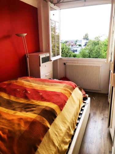 une chambre avec un lit et une grande fenêtre dans l'établissement Cosy appartement 10 min from Paris, à Bois-Colombes