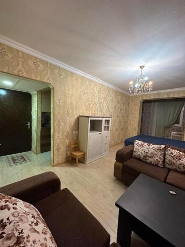 una sala de estar con una cama y un sofá en Kutaisi Apartment, en Kutaisi