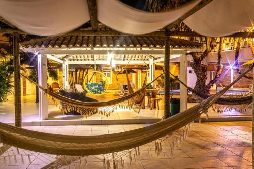 a hammock in the middle of a room at Pousada Corais Barra in Barra de São Miguel
