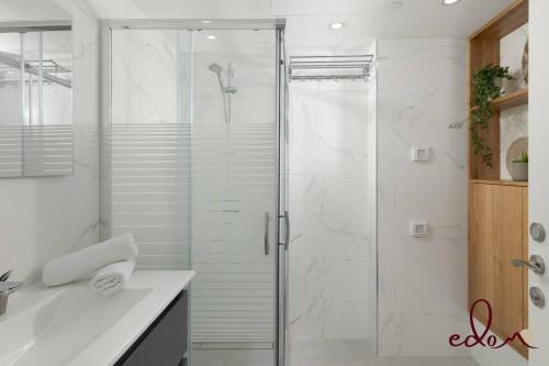Un baño con ducha con puerta de cristal. en דירה עם מרפסת במתחם סי סייד - By Edomlux, en Eilat