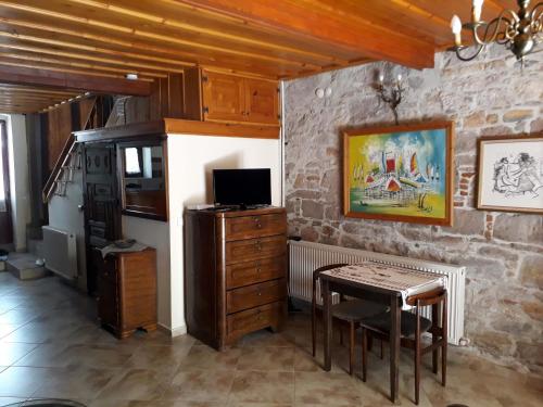 a dining room with a table and a television at Paydos Tatil Evi in Ayvalık