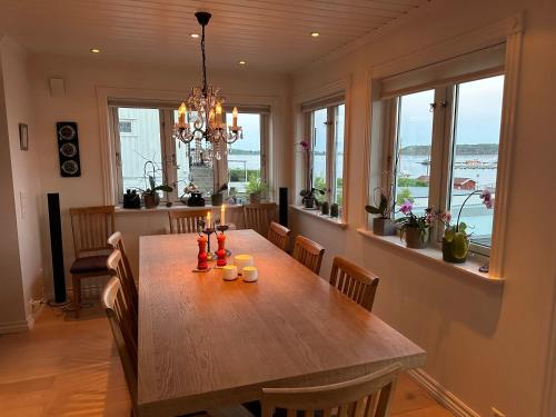 a dining room with a wooden table and windows at Ved sjøen, Husvik- Tønsberg, 2 hus! in Tønsberg