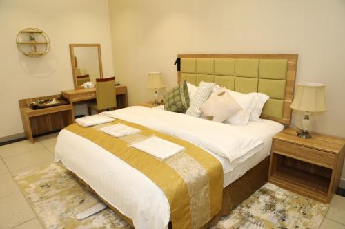 a bedroom with a large bed and a mirror at Warf Aldyafah Homes serviced Apartments in Riyadh