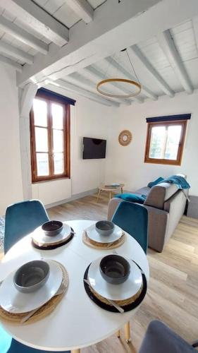 - un salon avec une table blanche et des chaises bleues dans l'établissement Appartement vue cathédrale, à Amiens