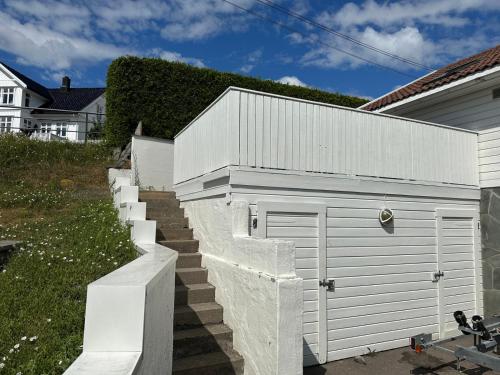 a white fence next to a white garage at Ved sjøen, Husvik- Tønsberg, 2 hus! in Tønsberg