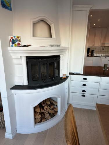 a fireplace in a kitchen with a white mantle at Ved sjøen, Husvik- Tønsberg, 2 hus! in Tønsberg