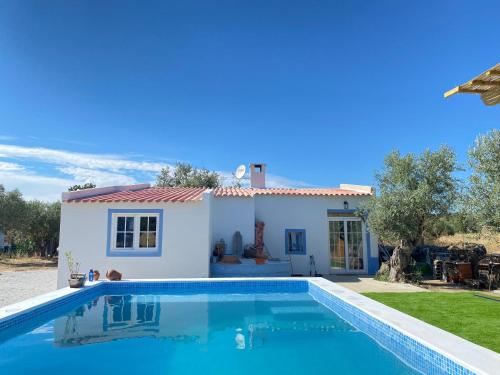a villa with a swimming pool in front of a house at Cor de Azeitona in Aldeia do Mato