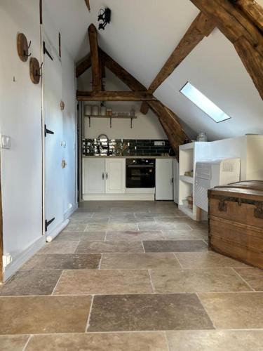 - une grande cuisine avec des appareils blancs et des plafonds en bois dans l'établissement Appartement au Cœur d'Auxerre, à Auxerre