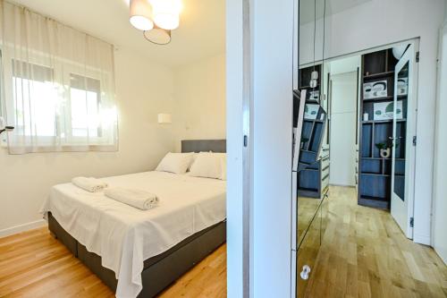 a bedroom with a bed and a glass door at Sea Whisper apartment Zadar in Zadar