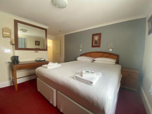 a bedroom with a large white bed and a mirror at The Beach Hotel in Brighton & Hove