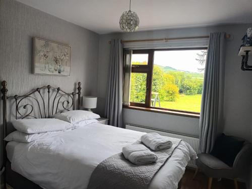 a bedroom with a bed with two towels on it at Drumgauty Cottage in Strabane