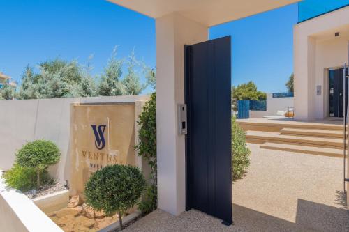 a door to a villa with a sign on a wall at Ventus Villa - A Luxury Sea View Retreat in Akrotiri in Akrotiri