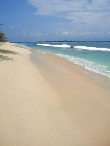 a sandy beach with the ocean in the background at Exotic house in Gili Meno