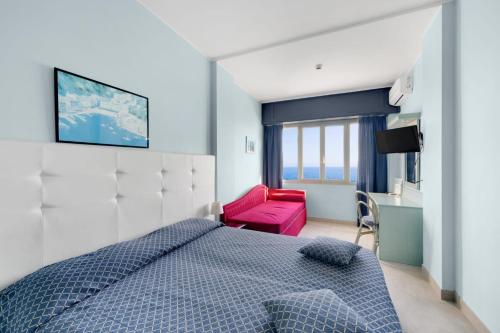 a bedroom with a blue bed and a red chair at Hotel La Perla Del Capo in Ospedaletti