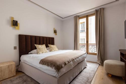 une chambre avec un grand lit et une fenêtre dans l'établissement Sublime Apt - 3BD-6P - Arc De Triomphe, à Paris
