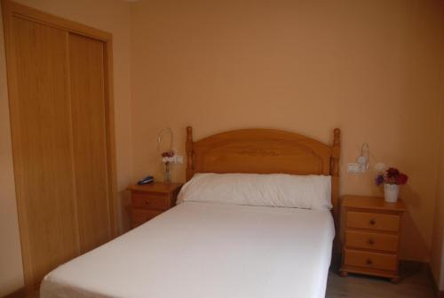 a bedroom with a white bed and two night stands at Hotel Flor de Sal in Porto do Son
