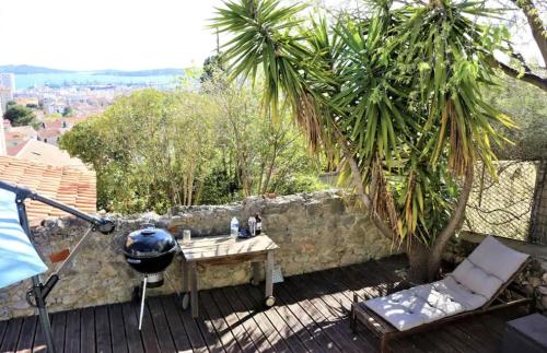 d'une terrasse avec une table et un mur en pierre. dans l'établissement Villa vue mer et jacuzzi, à Toulon
