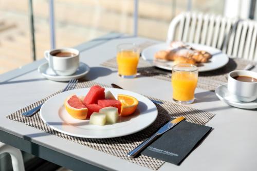 Una mesa con dos platos de fruta y tazas de café. en Hotel Best Mediterraneo, en Salou