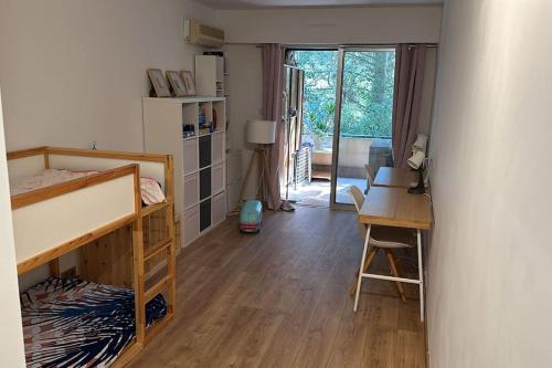 une chambre avec un bureau et un lit superposé et un bureau dans l'établissement Superbe appartement de 3p pieces dans residence avec piscine et climatisation, à Nice