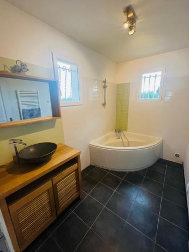 une salle de bain avec une baignoire et un lavabo dans l'établissement Charmante villa avec piscine chauffée, proximité des plages, à Vias