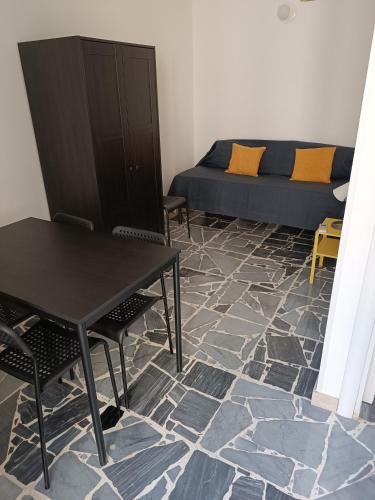 a room with a bed and a table and chairs at Cuore di Aci - Casa degli Zelanti in Acireale