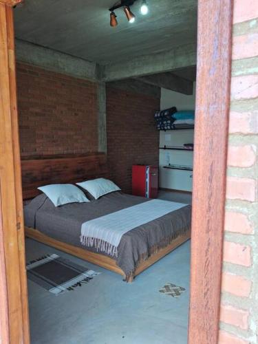 a bedroom with a bed in a brick wall at Suite Pedro - Casa Tapera Nova in Conceição da Ibitipoca