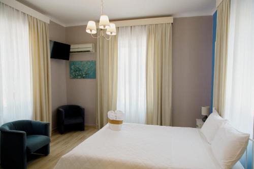 a bedroom with a white bed and a chair at Garden Bungalow in Kórinthos
