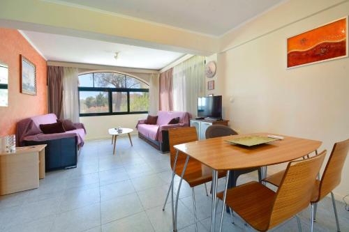 a living room with a table and a dining room at Calm & Peaceful in Gouvia