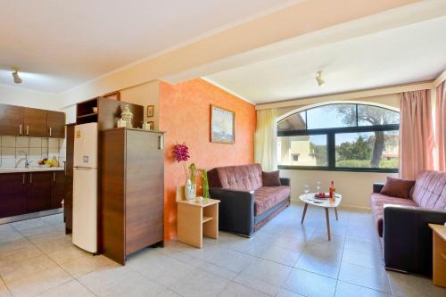 a living room with two couches and a kitchen at Calm & Peaceful in Gouvia