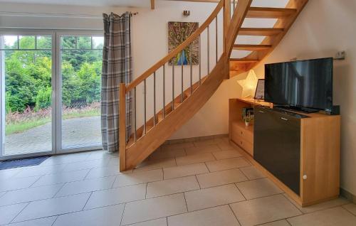 a living room with a television and a staircase at Lovely Home In Zermützel With Sauna in Zermützel