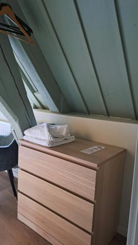 a wooden dresser in a room with a roof at Stadsklooster Dordt Hotel&Hostel in Dordrecht