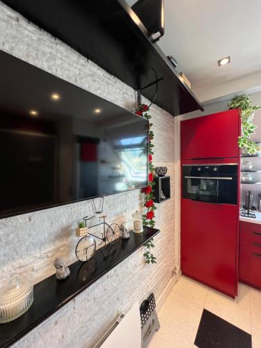 une cuisine avec des placards rouges et une porte rouge dans l'établissement JOIA PARIS - Montparnasse, à Paris