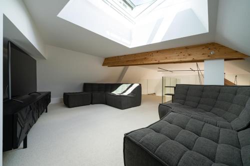 a living room with a couch and a television at Les Suites 7 Anges - Parking, Vue Cathédrale & Centre Historique Reims in Reims