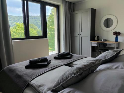 a bedroom with a bed with two black towels on it at Heima in Zawoja