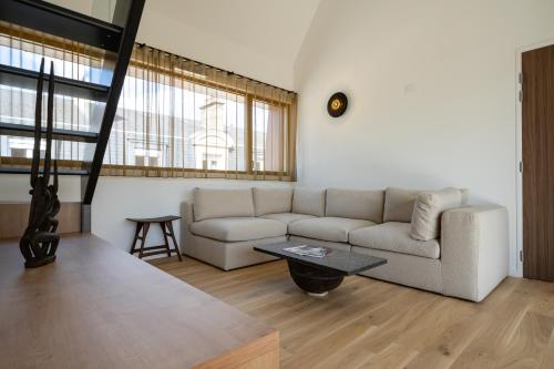 a living room with a couch and a table at Les Suites 7 Anges - Parking, Vue Cathédrale & Centre Historique Reims in Reims