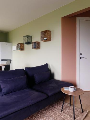 a living room with a blue couch and a table at Apartment in Lillestrøm with free parking and great view, sleep 3 people in Lillestrøm