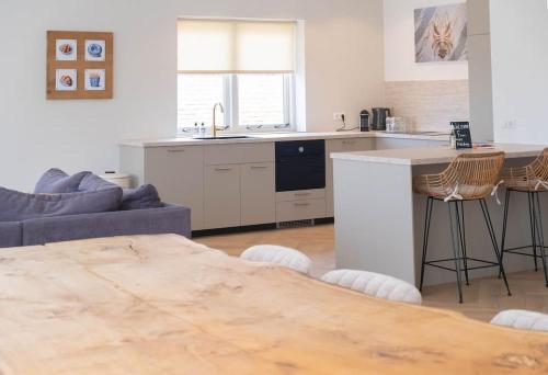 a kitchen with a couch and a table in a room at Sint Adelbertus in Egmond-Binnen