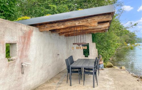 a table and chairs sitting under awning next to the water at 1 Bedroom Awesome Home In Gränna in Gränna