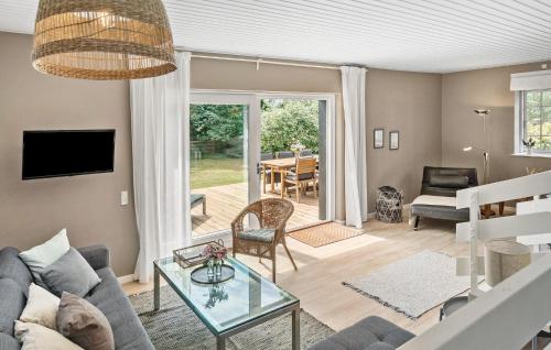 a living room with a couch and a table at 5 Bedroom Nice Home In Væggerløse in Marielyst