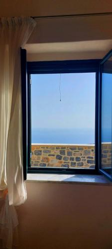 a window in a room with a view of the ocean at Refoulo Tower in Poliána